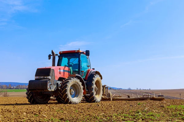 Czerwony Traktor Oruje Plantację Zbiorach Przygotowanie Gruntów Wysiewu Zielonego Nawozu — Zdjęcie stockowe