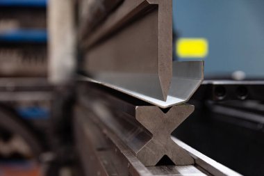 Modern bir bükme makinesinin metal parçalarını bükme işlemi. İnce galvanize metalden yapılmış uzun metal parçaları..