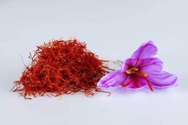 Beyaz arka planda bir sürü safran lekesi ve bir çiçek var. Dünyanın en pahalı baharatı. Safranın kalıcı bir kokusu vardır..