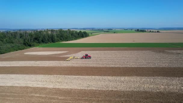 大規模な追跡トラクターは、現代の矢印で土壌を緩めます。農業機械にはGPSが装備されている. — ストック動画