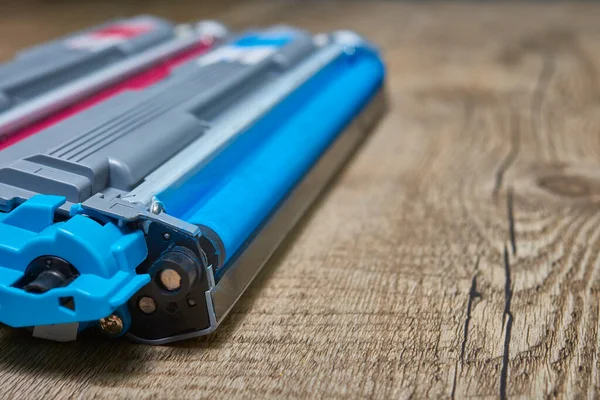 Cyan toner cartridges for a laser printer on wooden table