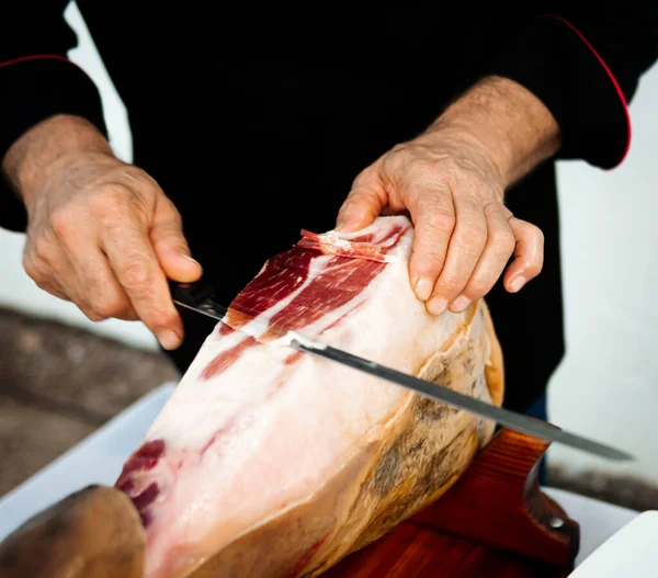 Profesyonel Iberico ya da Serrano jambonu dilimlenmiş domuz bacağını jambon bıçağıyla kesiyor.