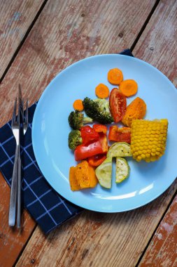 Fırında kızartılmış renkli sebzeler seni bekliyor, tahtadan arka planda, hadi deneyelim! Afiyet olsun.