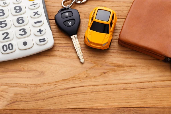 Car key with calculator on wood background — Stock Photo, Image