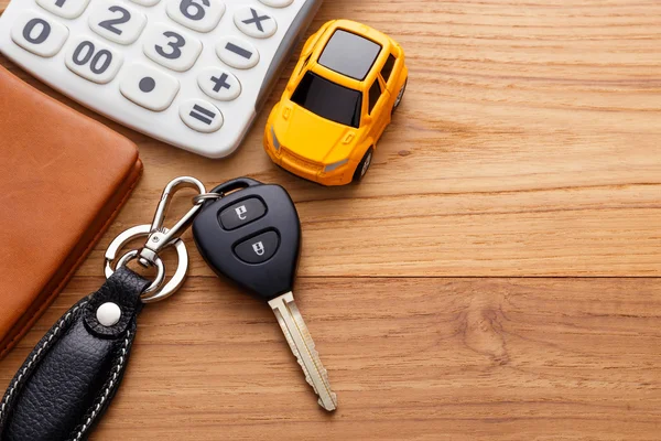 Car key with calculator on wood background — Stock Photo, Image