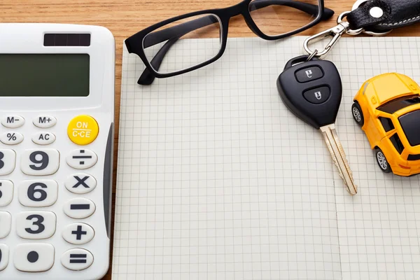 Blank notebook with car key and calculator — Stock Photo, Image