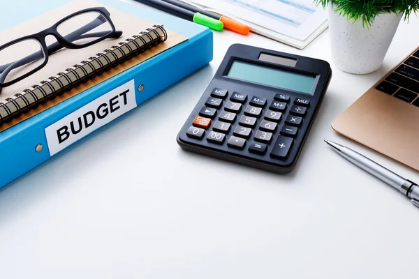 Piano di bilancio con calcolatrice su tavolo bianco — Foto Stock