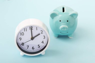 Mavi arkaplanda domuz kumbarası olan saat