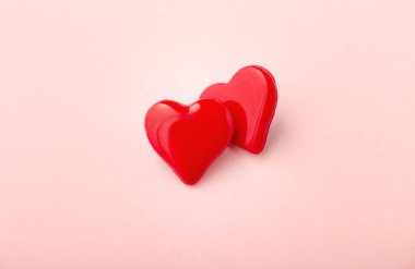 Pembe arka planda iki kırmızı kalp, aşk konsepti