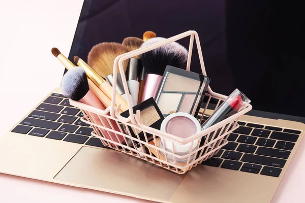 Makeup beauty online shopping business concept with shopping basket on laptop