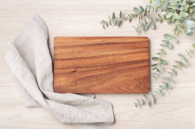 Ağaç kesme tahtası, keten peçete ve bitki, üst manzara.