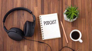 Not defterinde, ahşap masa üzerinde kulaklık ve üst görünüm ile podcast kelime
