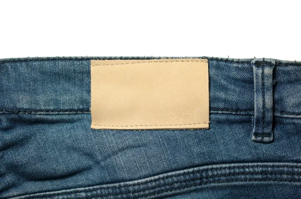 Etiqueta de cuero blanco en jeans aislados en blanco —  Fotos de Stock
