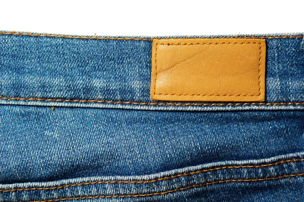 Etiqueta de couro em branco em jeans azul isolado em branco — Fotografia de Stock