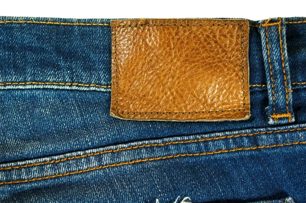 Kahverengi deri etiket üzerindeki mavi jeans — Stok fotoğraf