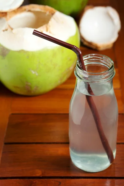 Кокосовая вода в бутылке с соломой — стоковое фото