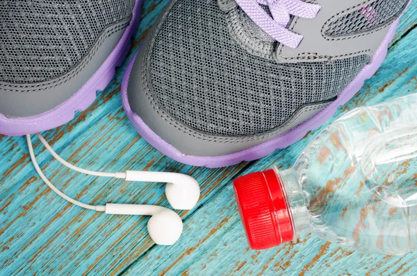 Sapatos esportivos com fones de ouvido e água potável — Fotografia de Stock