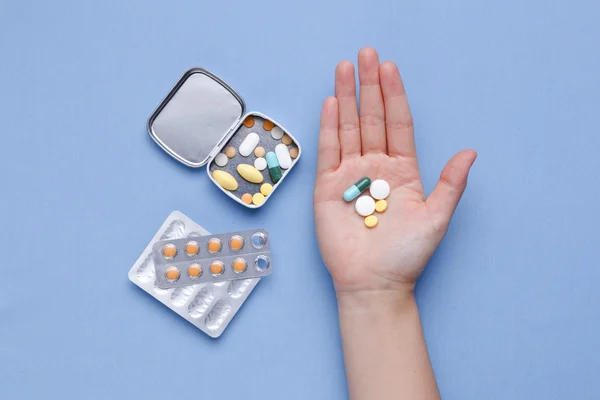 Таблетки и капсула с лекарствами в руке — стоковое фото