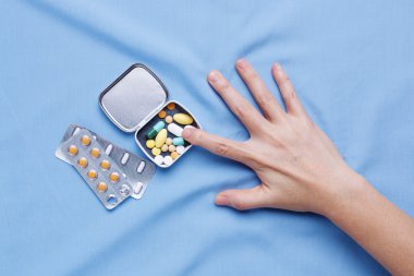 Acı hapları almaya çalışan el ile hastalık