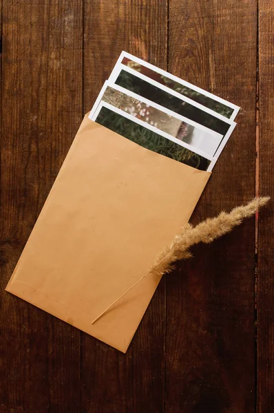 Photos Enclosed Beige Envelope Located Brown Wooden Table — Stock Photo, Image