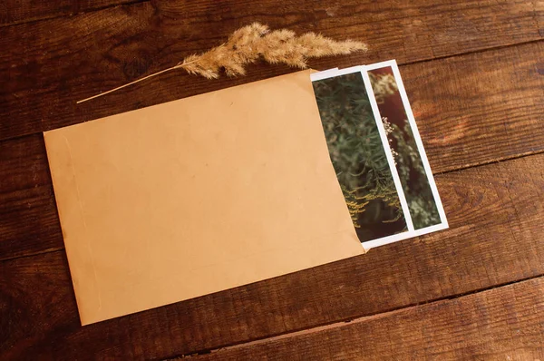 Photos Enclosed Beige Envelope Located Brown Wooden Table — Stock Photo, Image