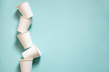 Tek kullanımlık beyaz kraft kağıt bardaklar kağıt mavi arka planda duruyor