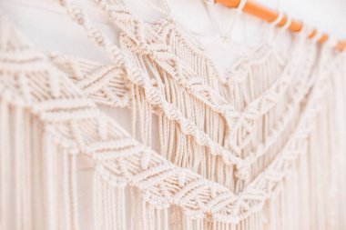 El yapımı makrome desen, ev ve düğün dekoru için kullanılan bej renkli pamuk iplikçikli duvar panelinin bir parçası.