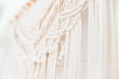 El yapımı makrome desen, ev ve düğün dekoru için kullanılan bej renkli pamuk iplikçikli duvar panelinin bir parçası.