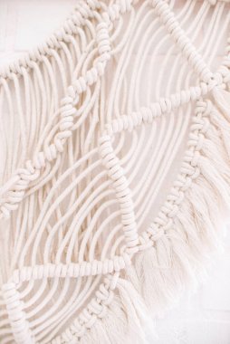 El yapımı makrome desen, ev ve düğün dekoru için kullanılan bej renkli pamuk iplikçikli duvar panelinin bir parçası.