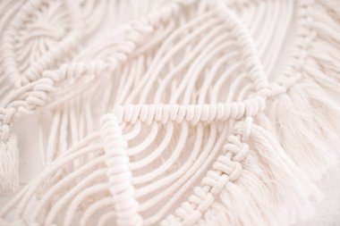 El yapımı makrome desen, ev ve düğün dekoru için kullanılan bej renkli pamuk iplikçikli duvar panelinin bir parçası.