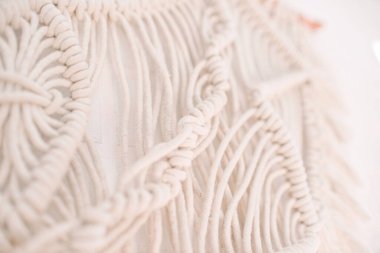 El yapımı makrome desen, ev ve düğün dekoru için kullanılan bej renkli pamuk iplikçikli duvar panelinin bir parçası.