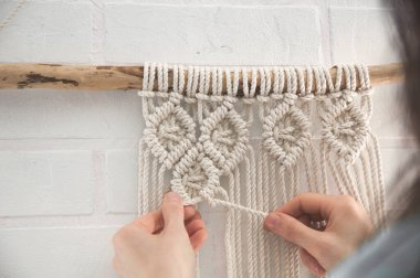 Ev yapımı için makrome tekniği ve prodüksiyon sürecinde düğün dekoru kullanılarak doğal renk pamuk ipliklerinden yapılmış boho duvar resmi