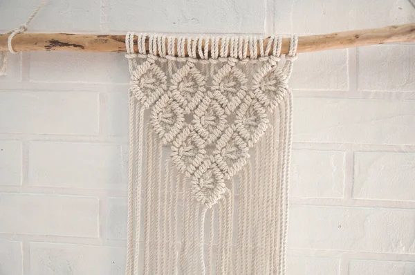 Boho wall mural made of natural color cotton threads using macrame technique for home and wedding decor