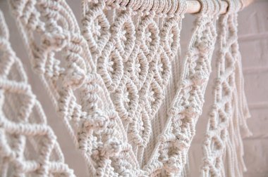 El yapımı makrome doku deseni yakın plan. El yapımı makrome. Ahşap çubukla 100 adet pamuk duvar süslemesi. İç mekanda modern dekorasyon.