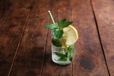 Limonlu ve naneli mojito yaz turunçgil kokteyli. Kahverengi ahşap masada limonlu soğuk limonata..