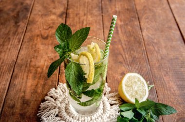 Limonlu ve naneli mojito yaz turunçgil kokteyli. Kahverengi ahşap masada limonlu soğuk limonata..