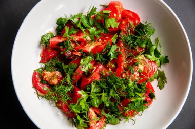 Beyaz tabakta maydanoz ve dereotlu salata. Kilo vermek için sağlıklı yiyecekler, vejetaryen yemekleri. Taze sebzeler..