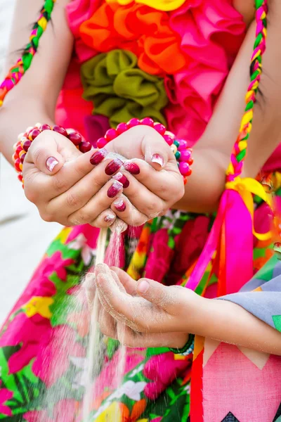 Falling sand from woman hand in a hands of child