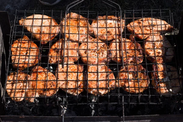 Fleischsteak auf dem Grill des Barbecue-Herstellers wird in den Ecken des Grills zubereitet. Köstliche große Dönerstücke mit Gewürzen und Senf auf dunklem Grill-Hintergrund. Nahaufnahme. — Stockfoto