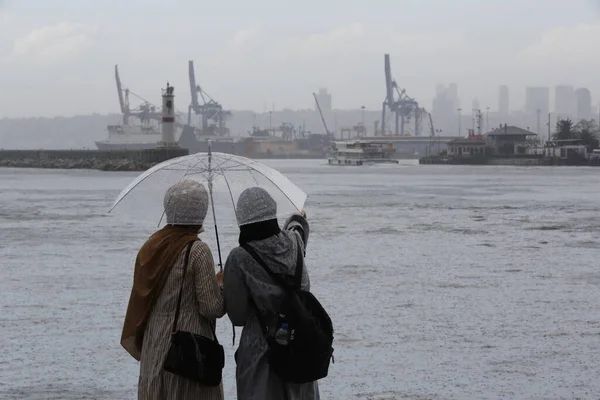 Δύο Νεαρές Γυναίκες Στέκονται Δίπλα Στη Θάλασσα Μια Βροχερή Μέρα — Φωτογραφία Αρχείου