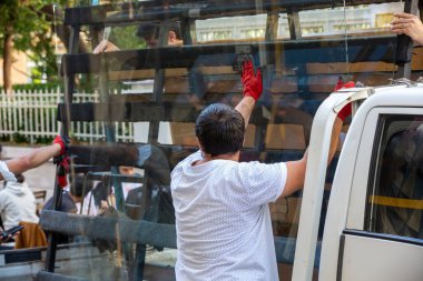 Önde cam taşıyan bir işçi.