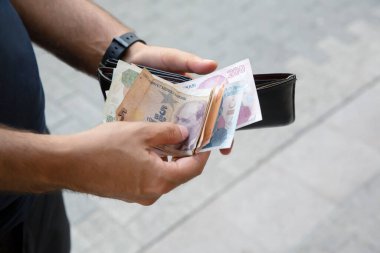 Cüzdanından para alan adam.