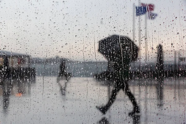 Adam yağmurlu bir günde yürüyor.