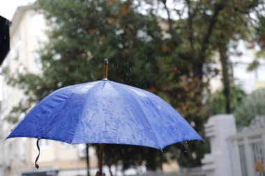 Yağmurlu bir gün ve mavi bir şemsiye