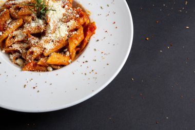 İzole edilmiş siyah arkaplanda Penne arabiata yemeği