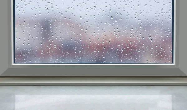 Front view window sill on falling rain drops