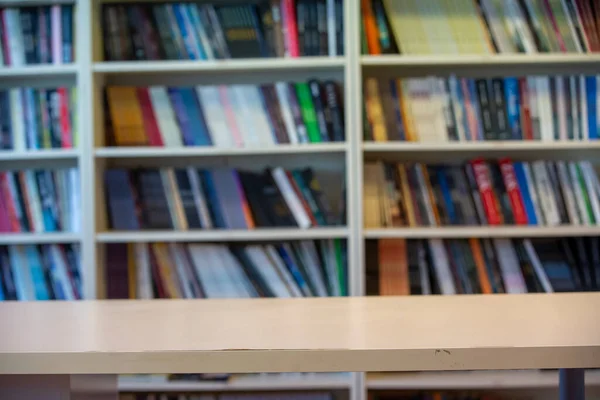 Holztisch Vor Bücherregalhintergrund — Stockfoto