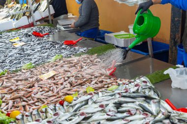 Balıkçılar balıkları taze tutmak için su döker. ön görünüm