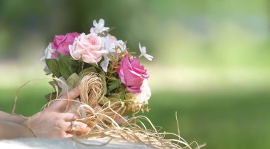 Gelin eli parkta çiçek tutuyor. Seçici odak