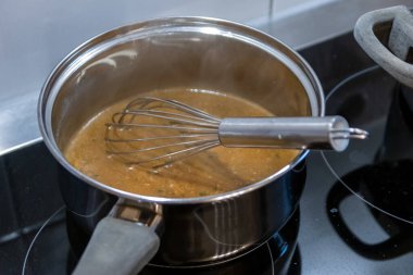 Mutfakta elektrikli ocakta çorba pişirmek.